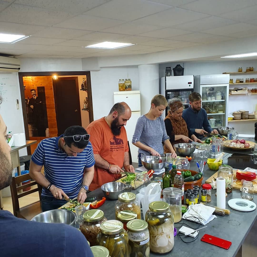 Alumnos cortando verduras alrededor de la mesa central del aula durante una sesión práctica