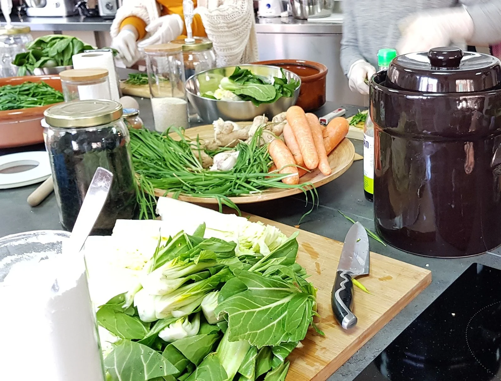 Mesa de trabajo con verduras y fermentos preparados al inicio de una sesión práctica