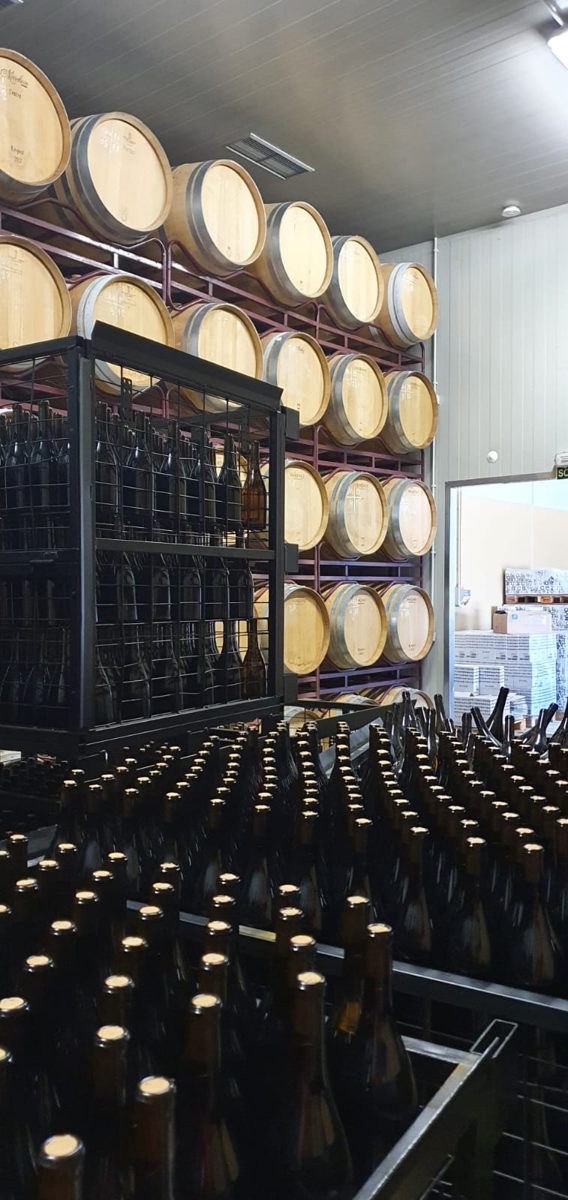 Sala de crianza con barricas de madera apiladas en un celler